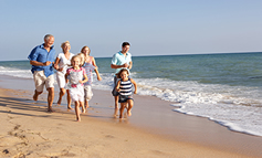family running on a beach enjoying life and financial security